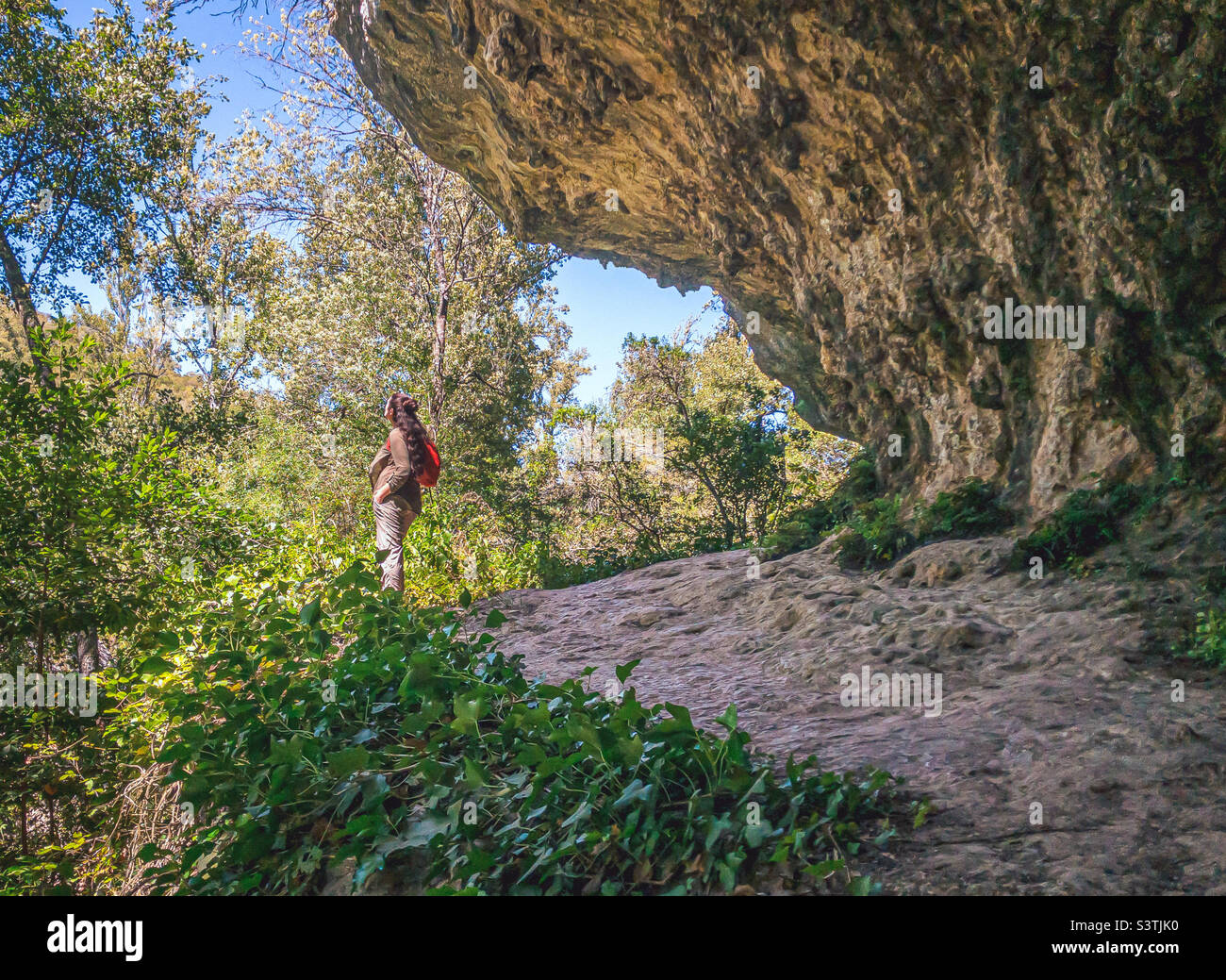 Female hikers stands below a rocky outcrop on the edge of a hiking trail in Lapas, Central Portugal - Smartphone Captured Stock Image