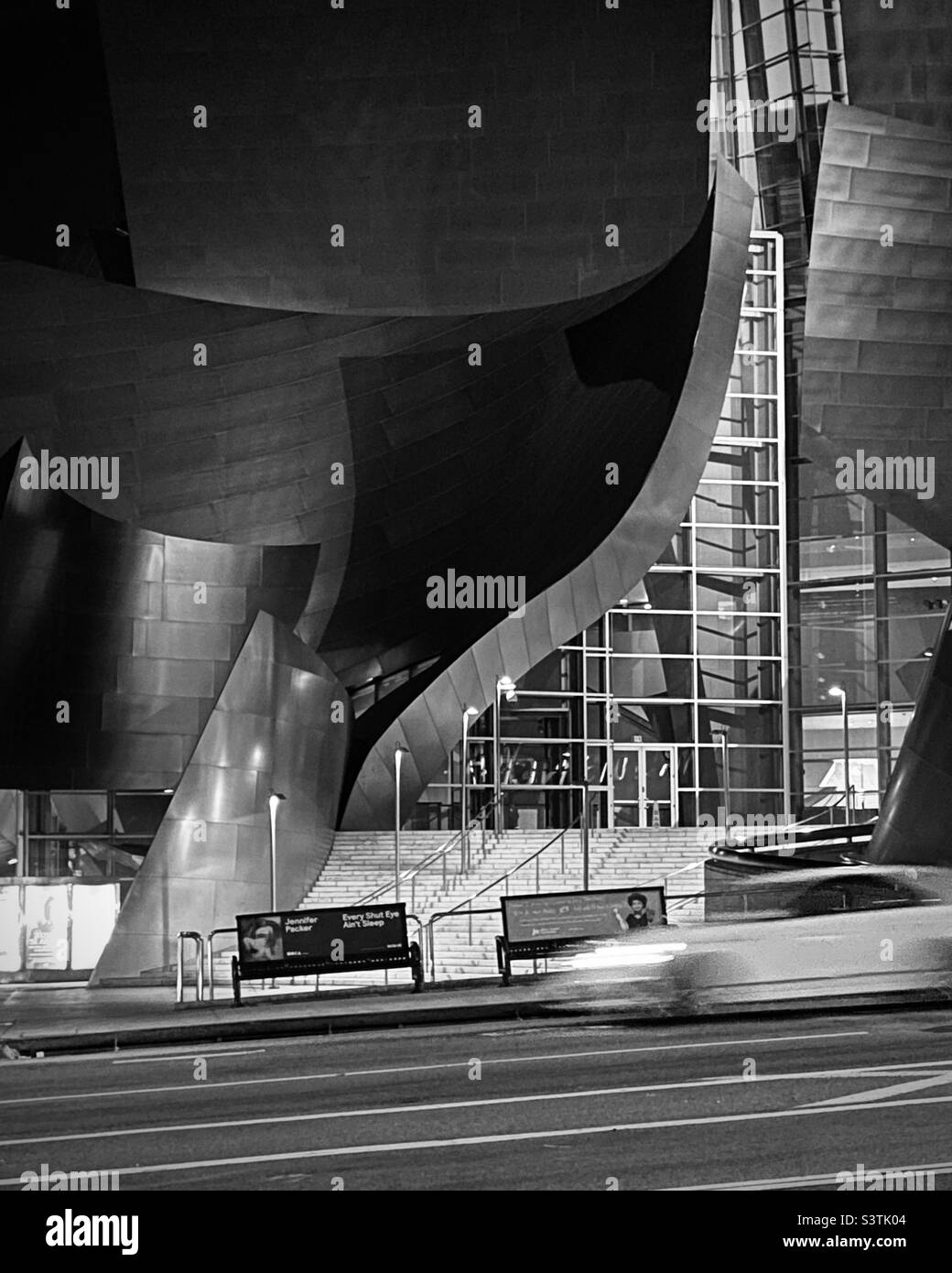 LOS ANGELES, CA, SEP 2021: motion-blurred car speeds past the Walt Disney Concert Hall in Downtown at night. Black and white Stock Photo
