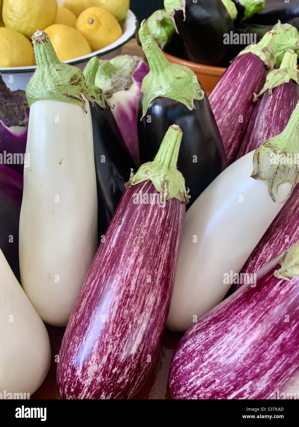 Mixed aubergines at food market Stock Photo