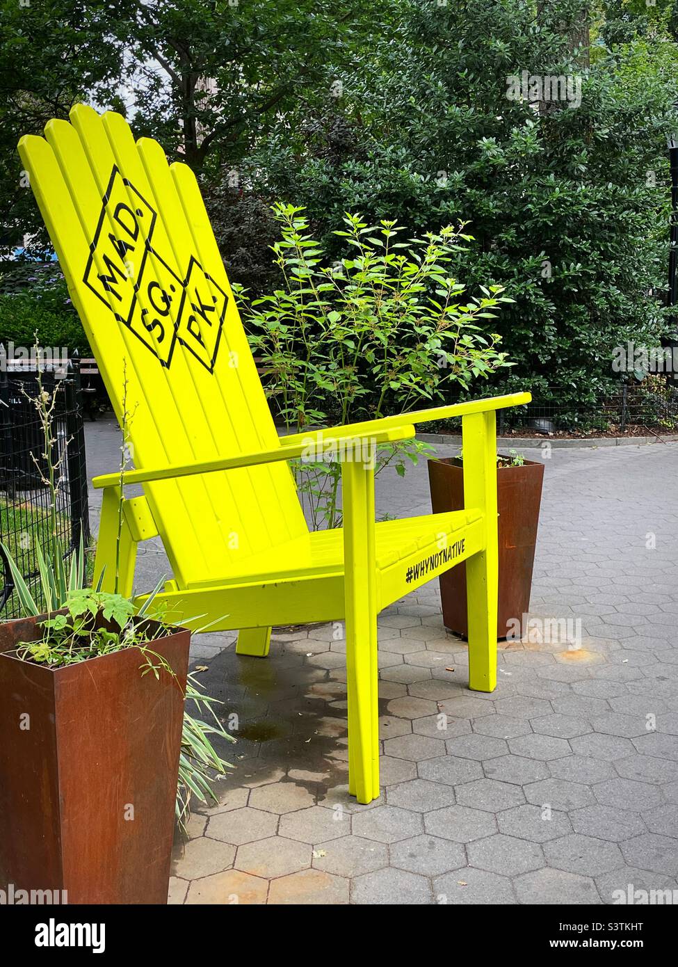 A bright neon green Adirondack chair in Madison Square, Park during a sunny summer afternoon, 2022, USA, NYC Stock Photo