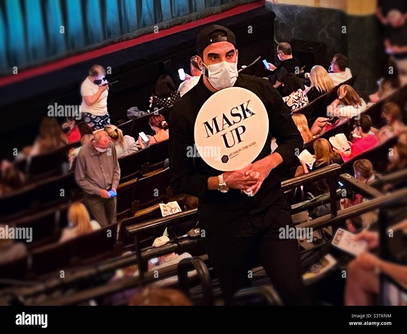 An usher with a mask up sign inside the Hudson Theatre before a performance, June 20 22, New York City, USA - Smartphone Captured Stock Image