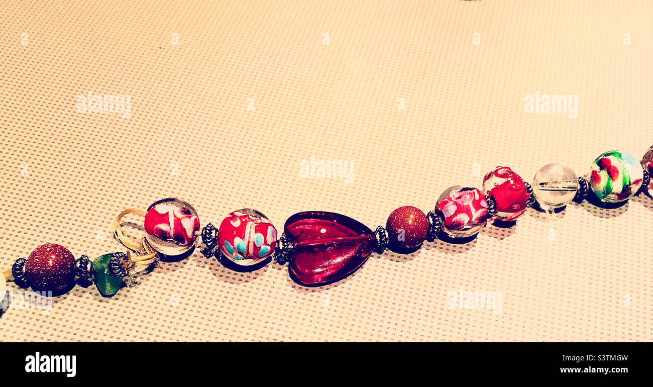 Pretty Red Toned Glass Beads in An Unravelling Bracelet Stock Photo