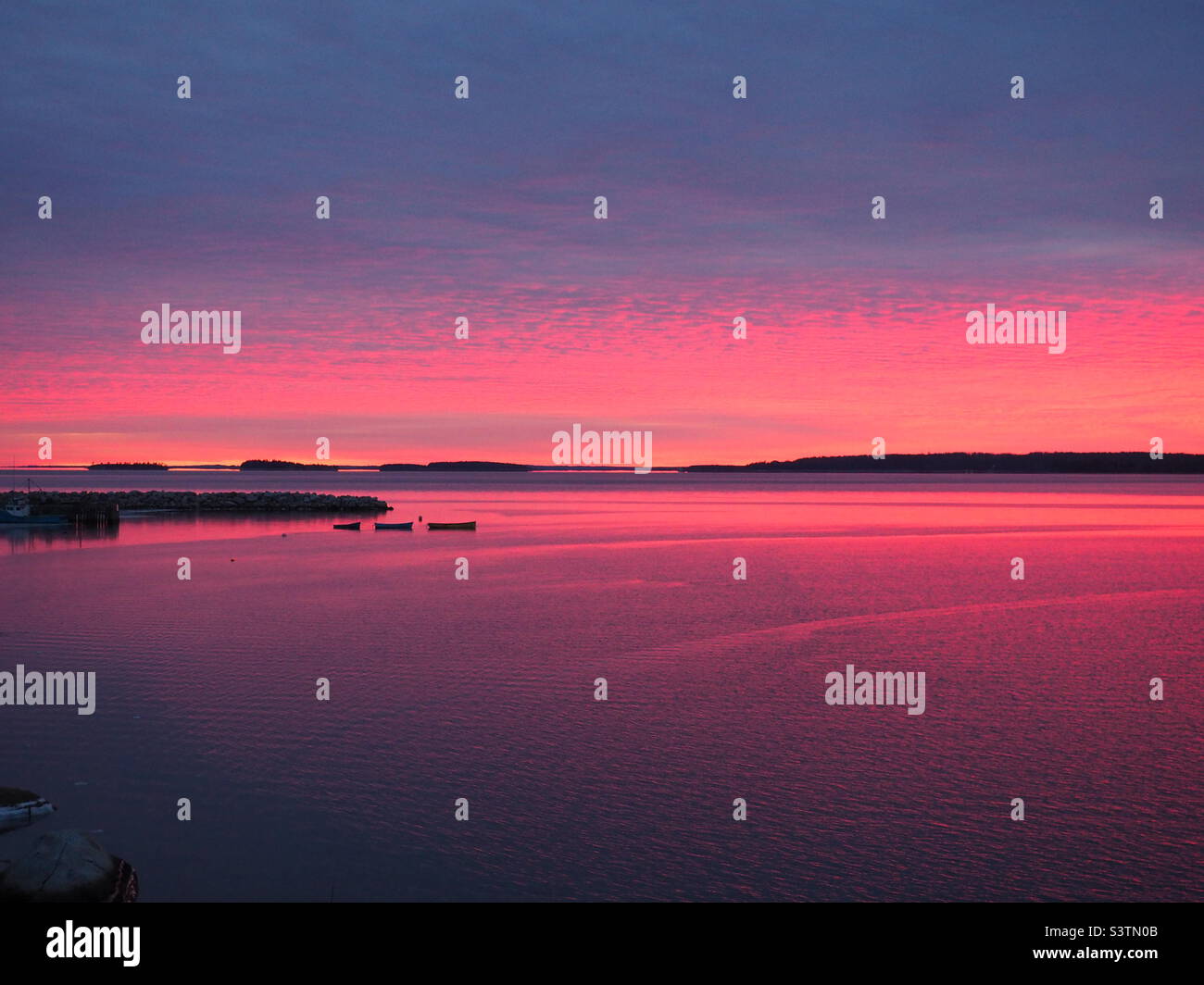 Sunset reflected in water below Stock Photo