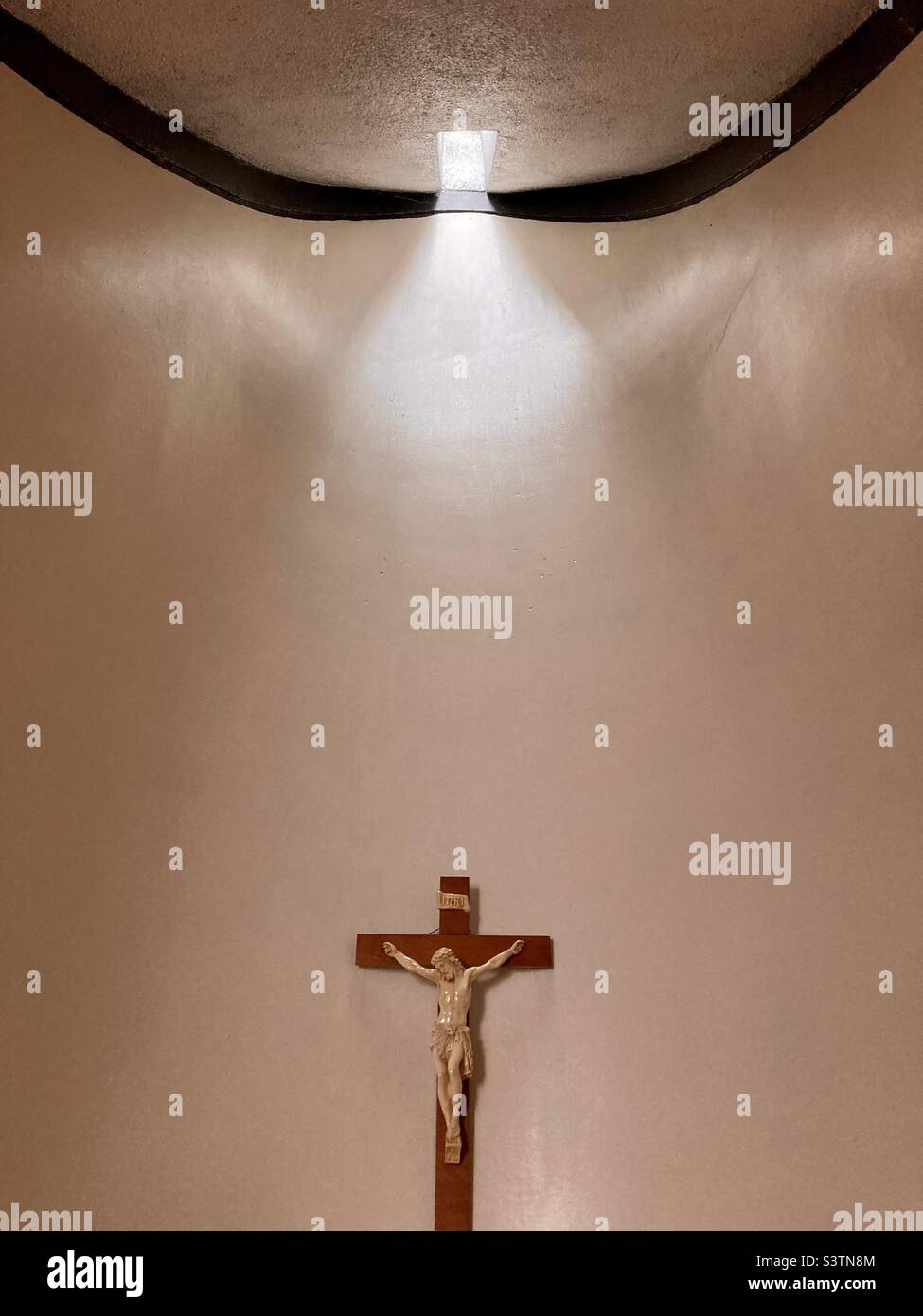 Crucifix within a church with a burst of light Stock Photo