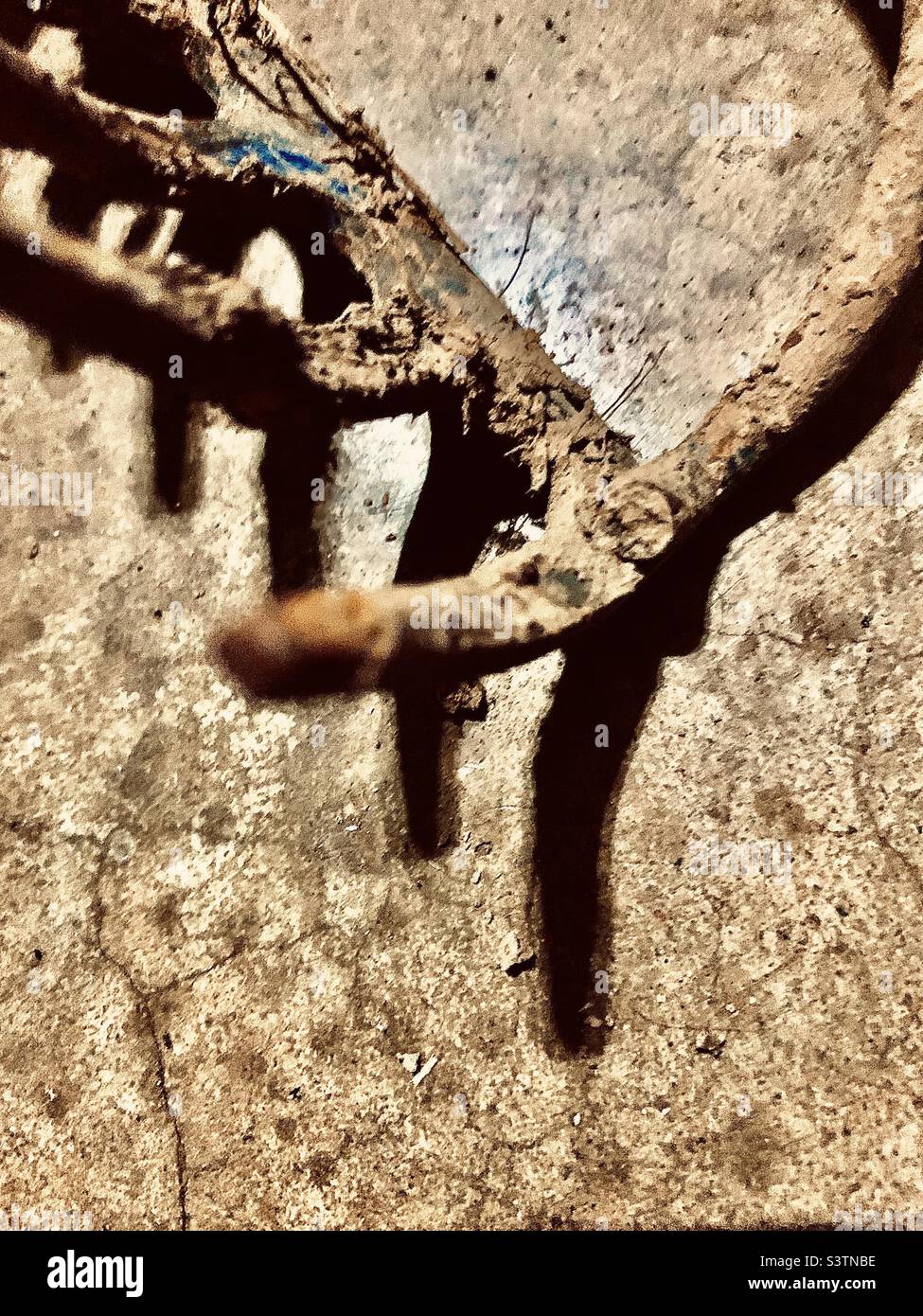 Closeup detail of muddy rake with shadow and print space - Smartphone Captured Stock Image