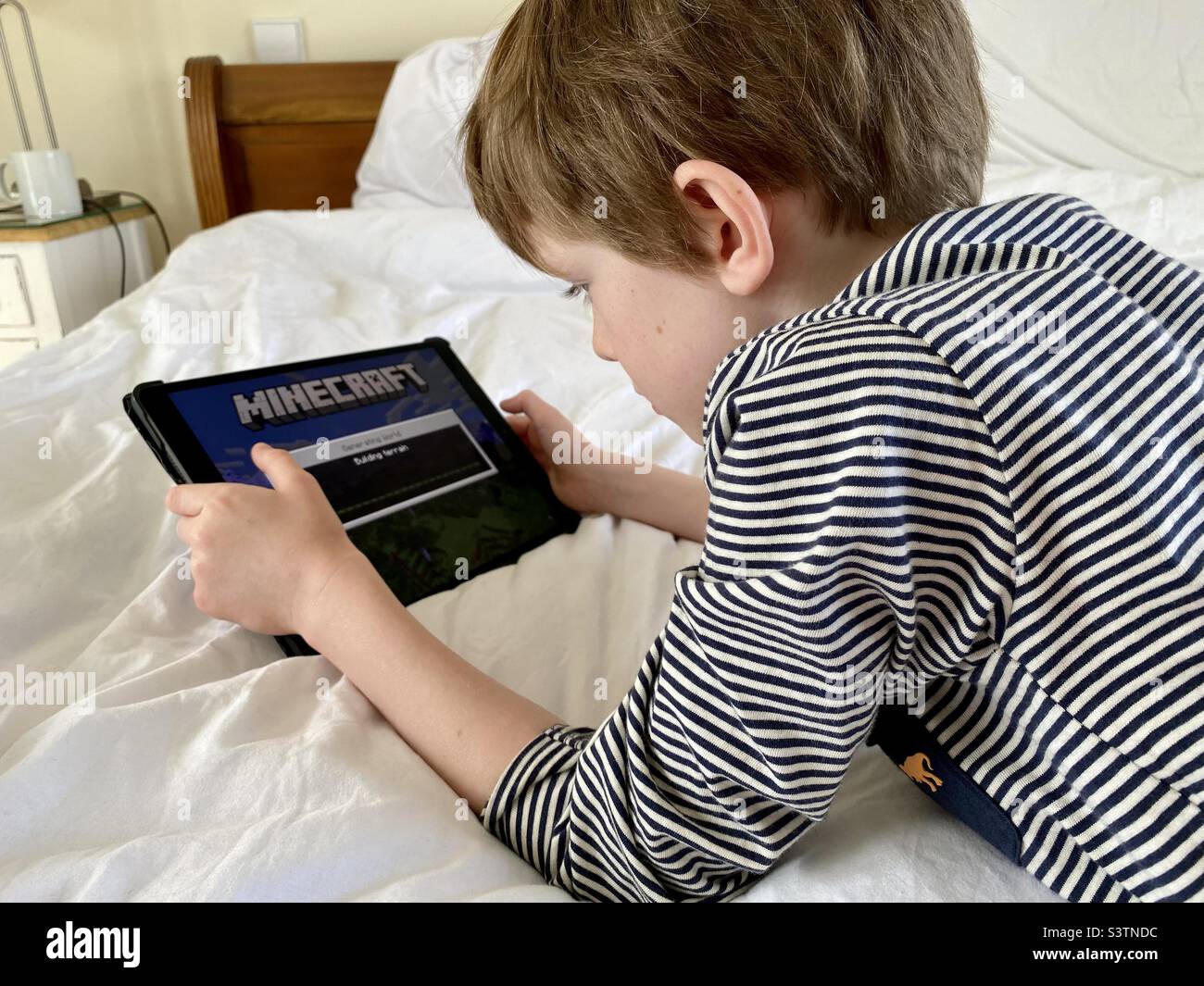 Little boy playing Minecraft on an iPad Stock Photo