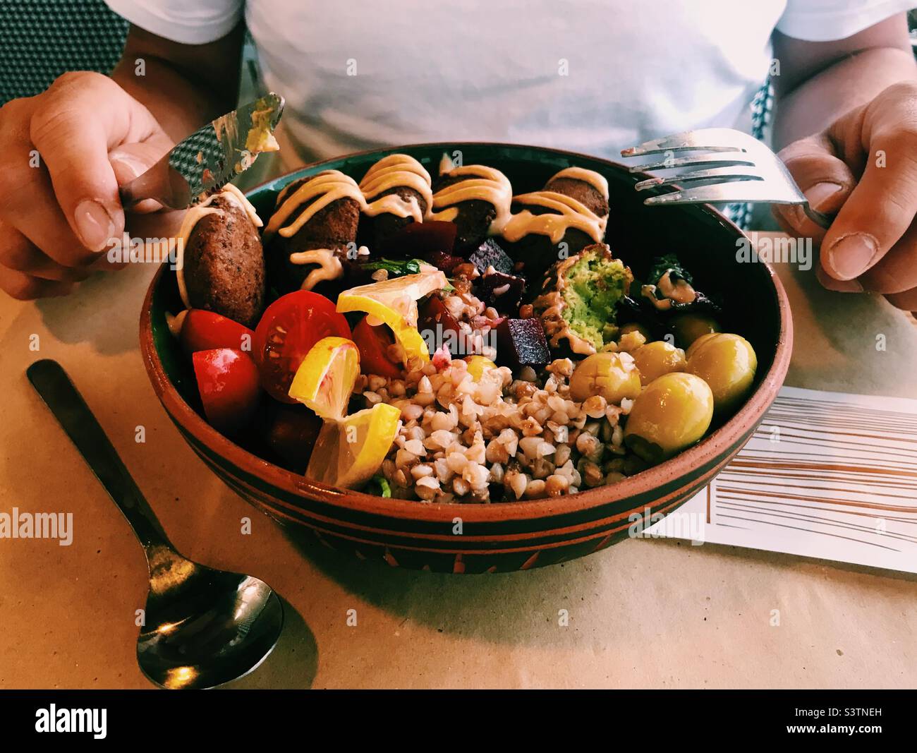 Man about to eat a vegan Buddha bowl food in Cappadocia at Sisters vegan restaurant - Smartphone Captured Stock Image