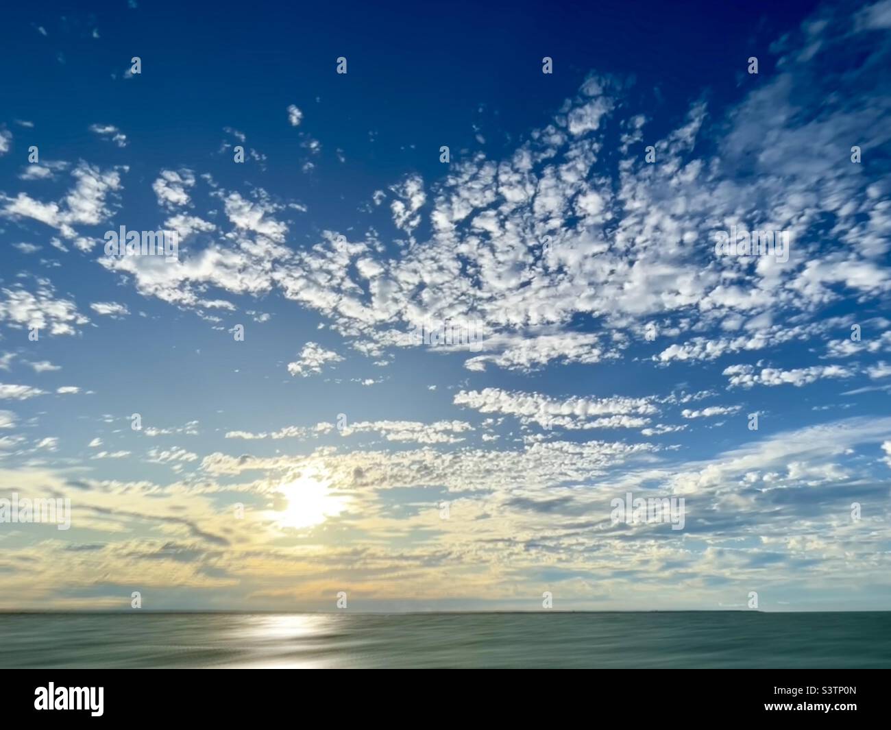 Sun and clouds over ocean with motion effect - Smartphone Captured Stock Image