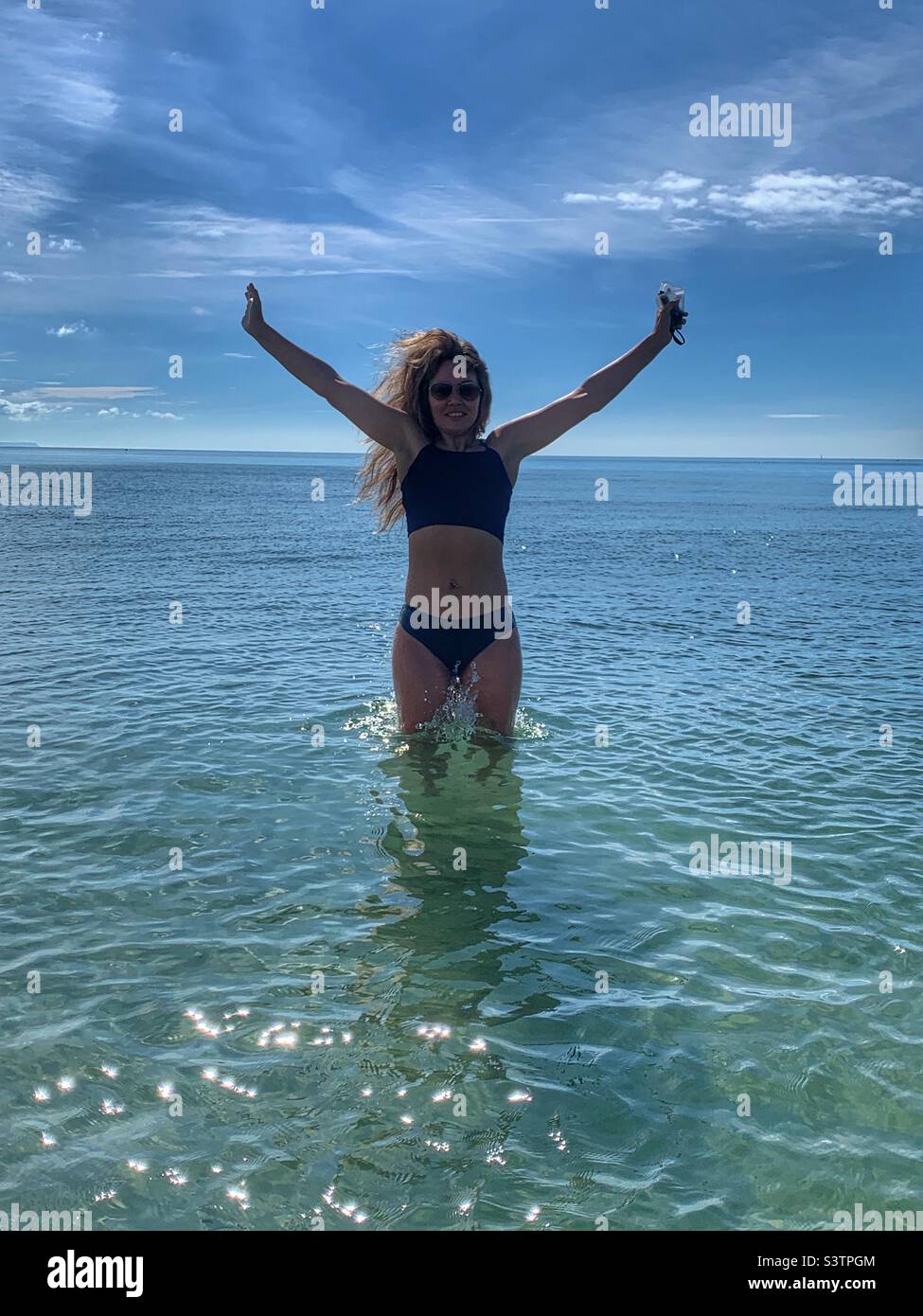Woman jumping out the water in bikini - Smartphone Captured Stock Image