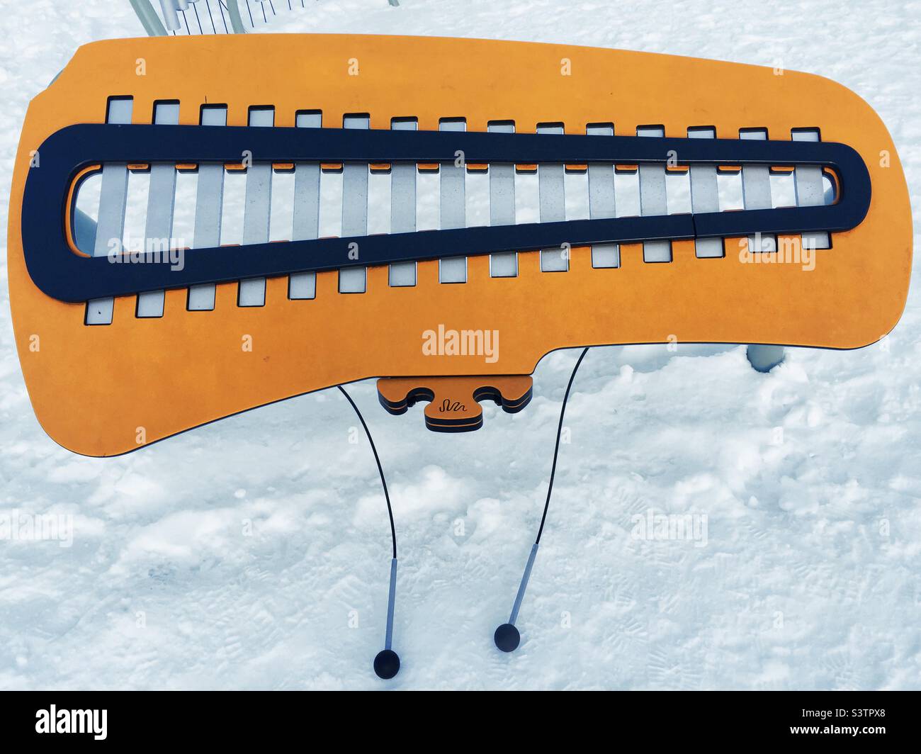 Musical instrument in snow. A giant xylophone. Outdoors, in the play area of a public park, Ontario, Canada. Music in all seasons. Stock Photo