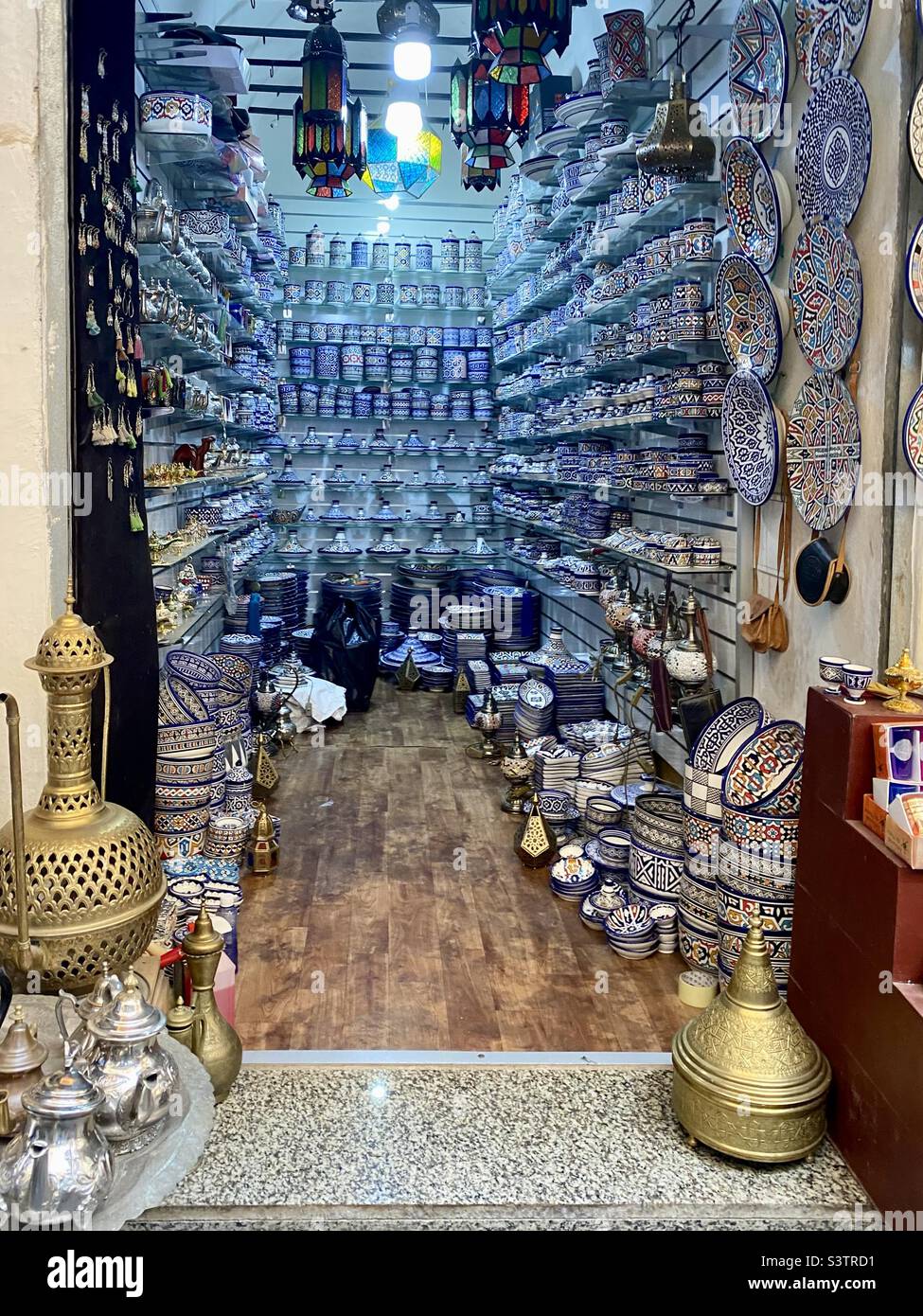 Tala’a Kebira decorative ceramic plates and bowls souk in Medina of Fes ancient market in Fez, Morocco, North Africa - Smartphone Captured Stock Image