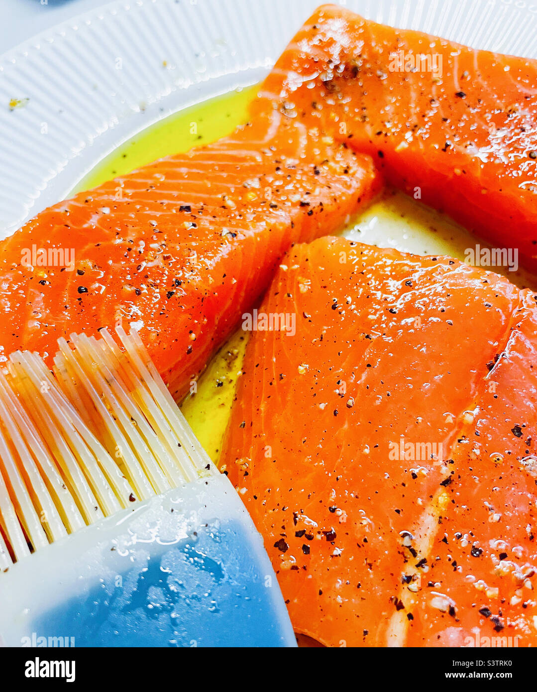 Close up of fresh salmon fillets being prepped for grilling in a residential kitchen, 2022, USA Stock Photo
