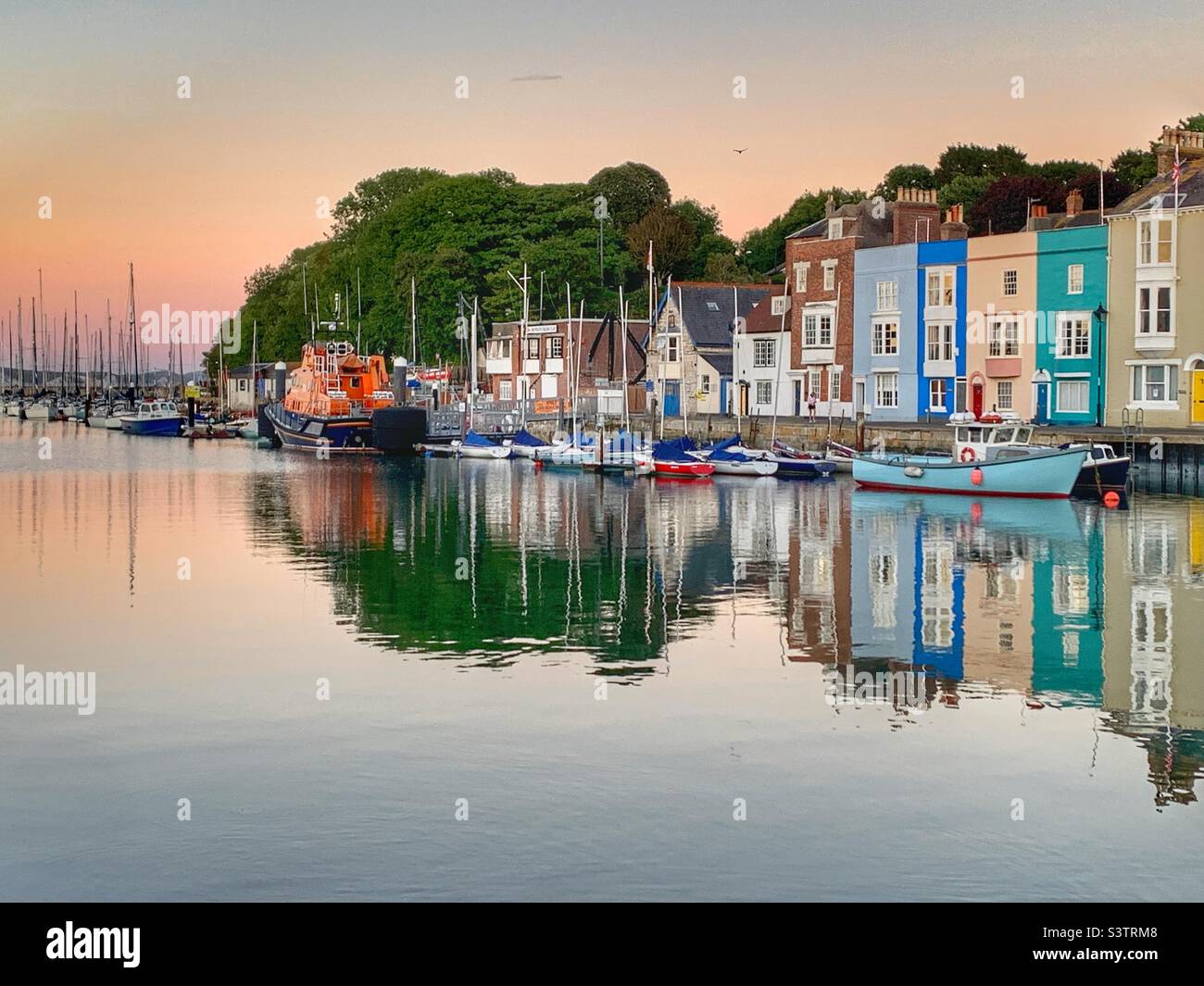Reflection of houses in the water at Weymouth harbour Stock Photo