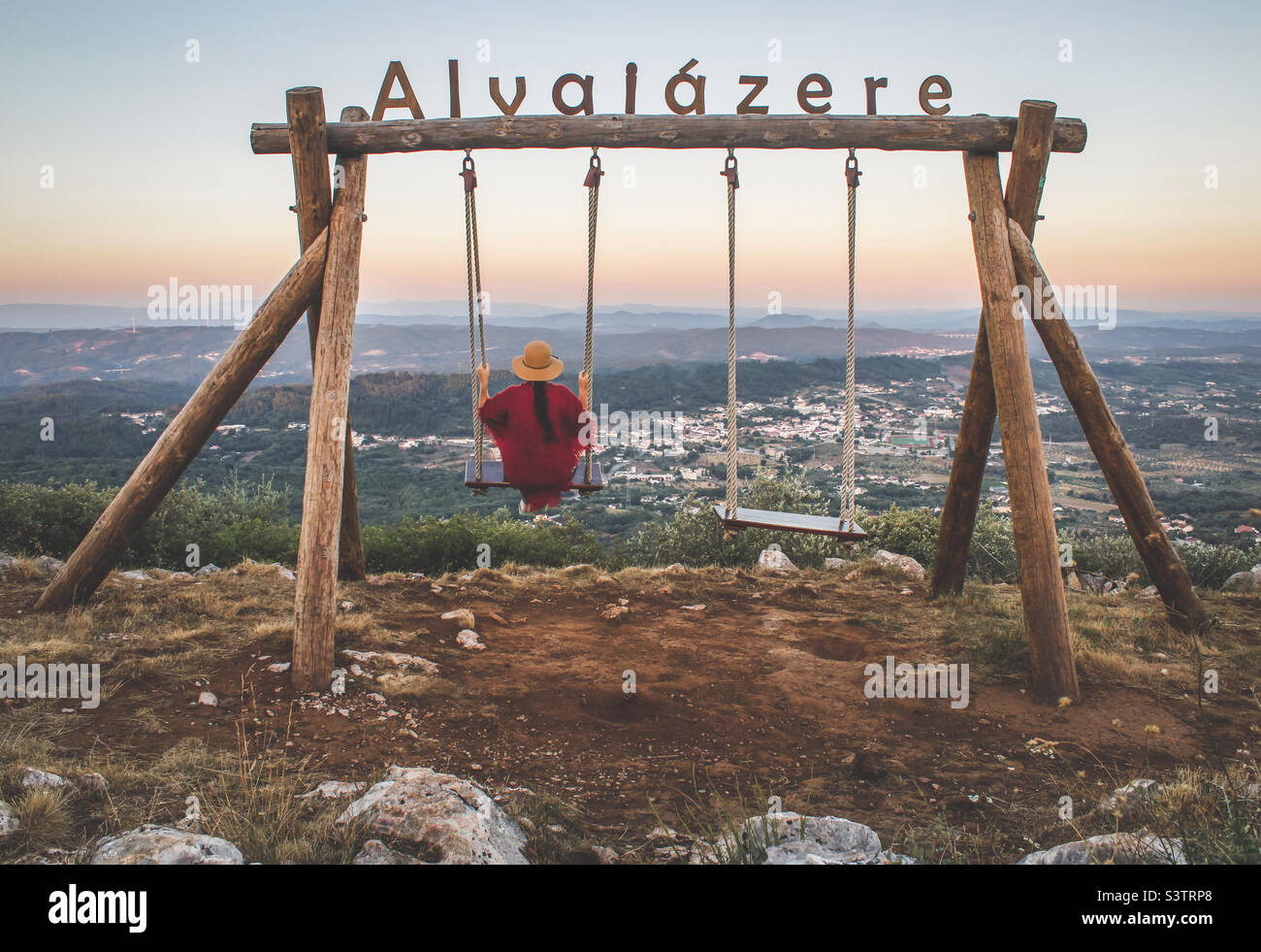 A women enjoys the early evening view from the swing that overlooks Alvaiazere in Central Portugal - Smartphone Captured Stock Image