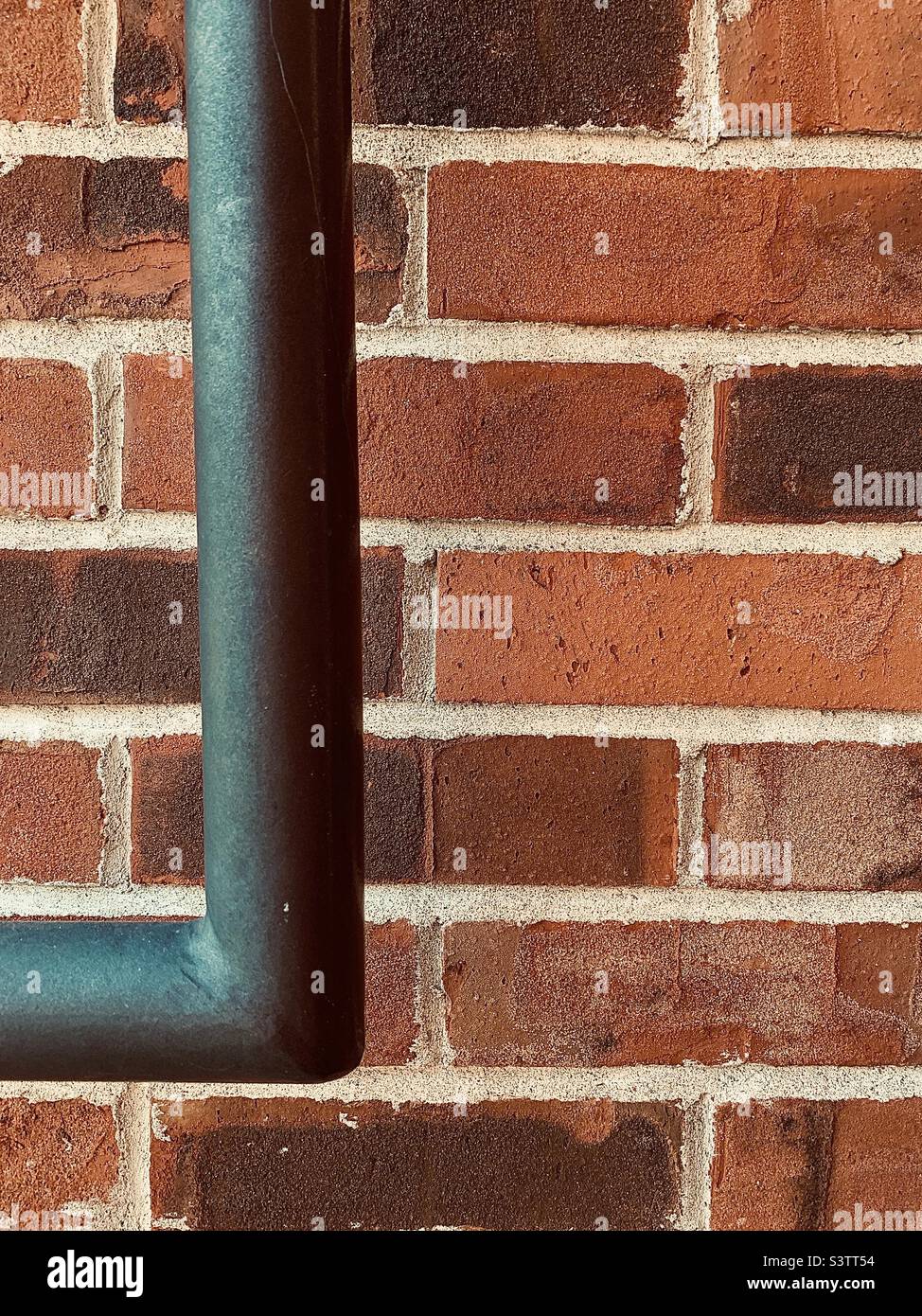 Brick Wall. Closeup portion of red brick wall with black bar Stock Photo