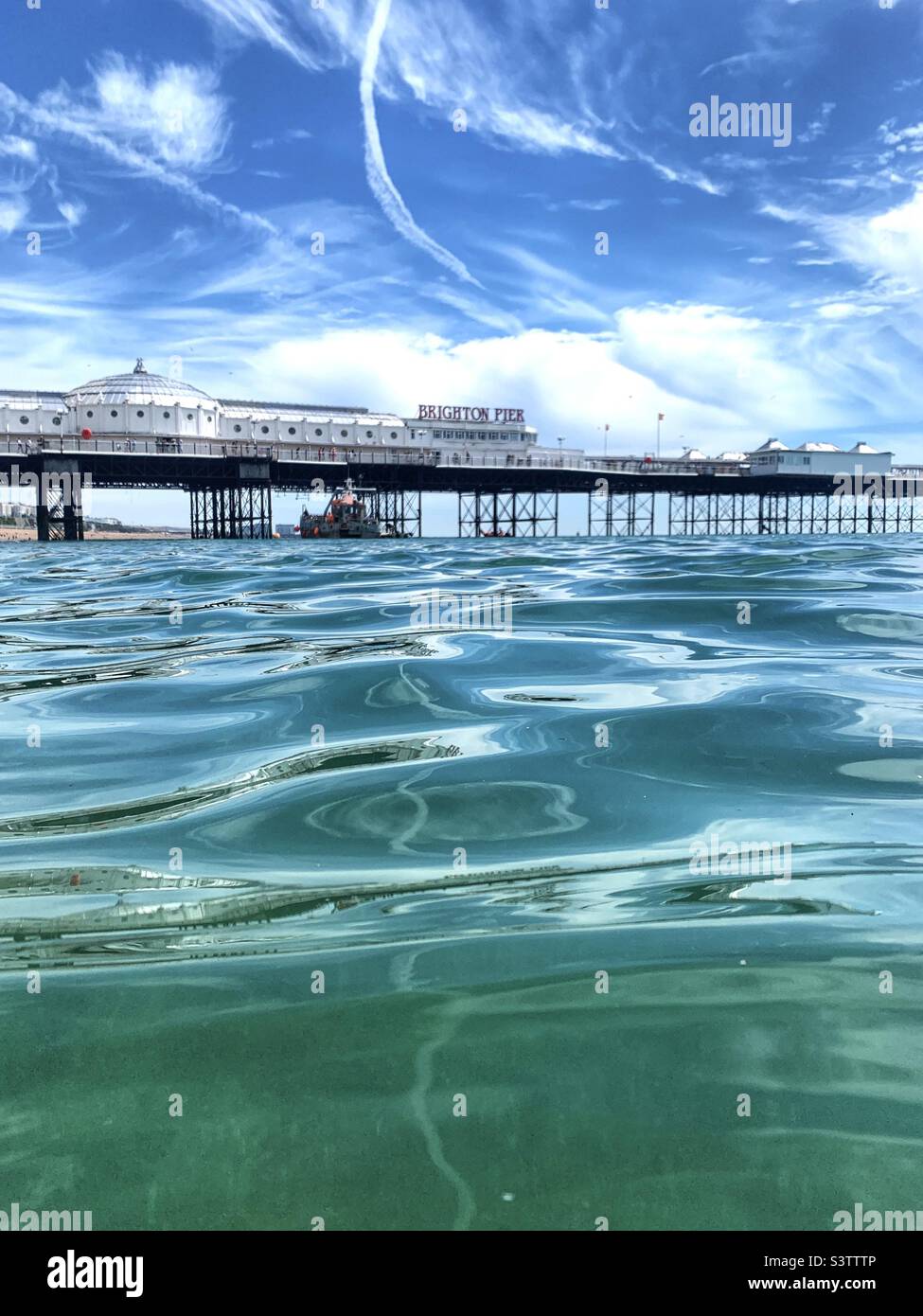View of Brighton pier across the water in summer Stock Photo