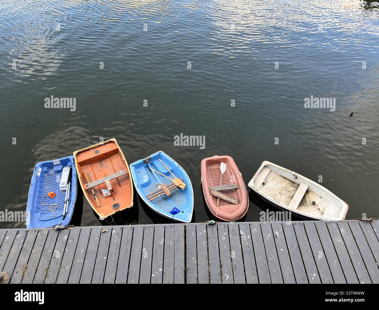 Five dinghies moored by a dock Stock Photo