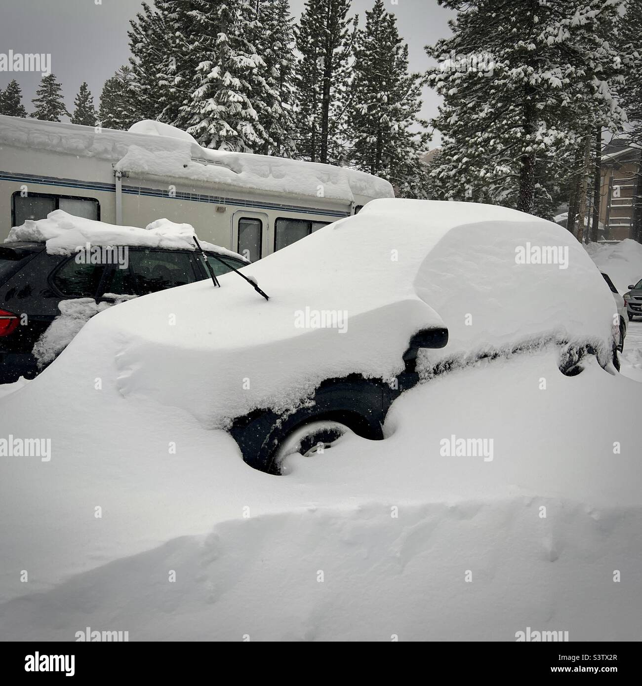 Car covered in deep snow after being left in a parking lot, Mammoth Mountain, California - Smartphone Captured Stock Image
