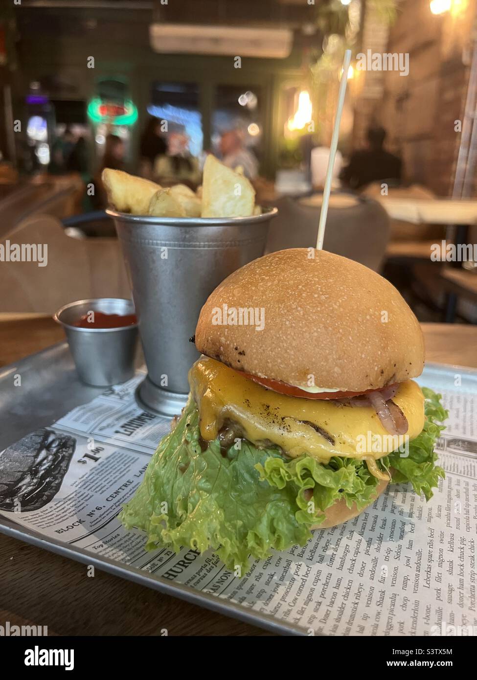 Bio hamburger with fried potatoes in a pub Stock Photo