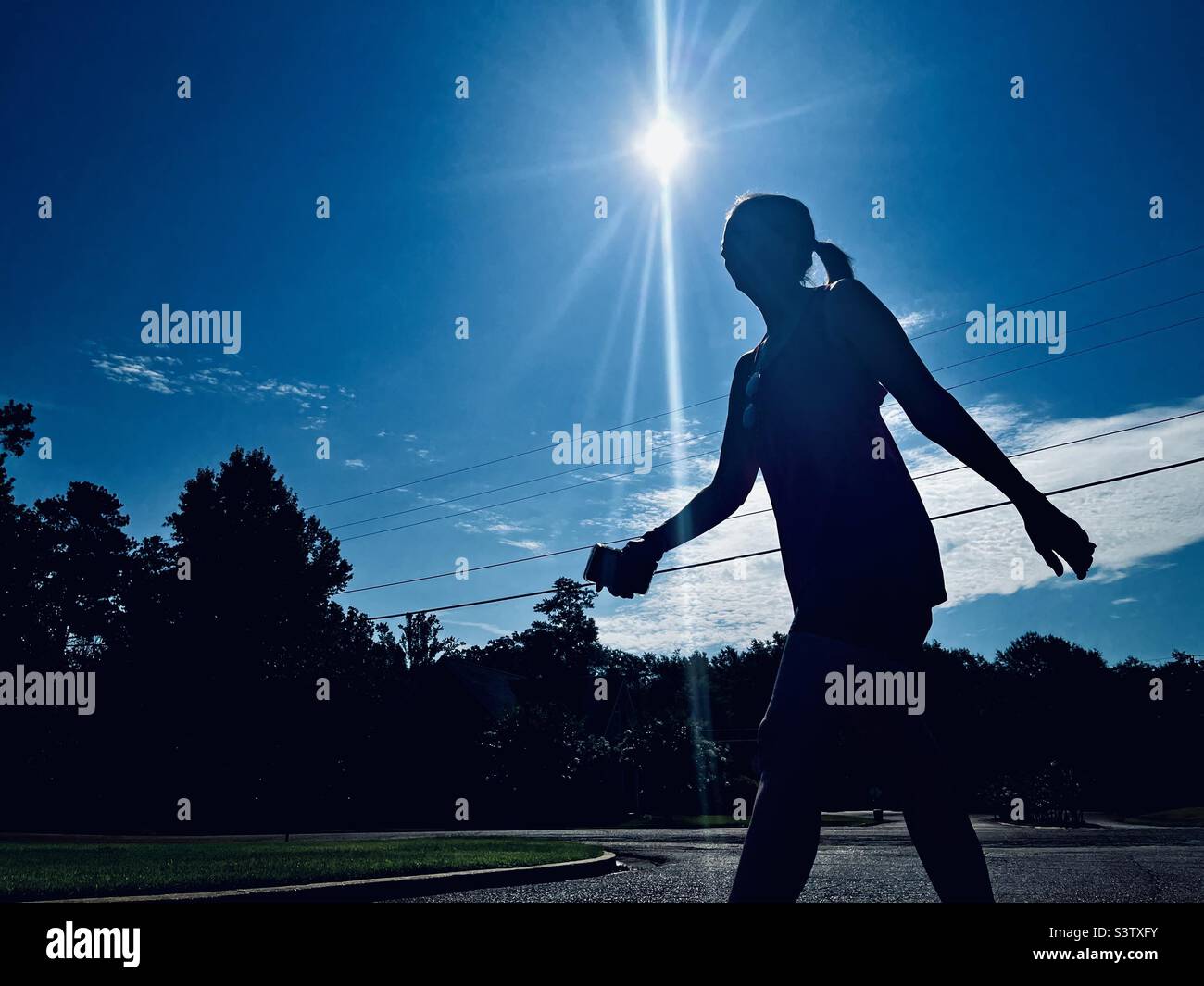 Holly Tippett, with cell phone in hand, walks her neighborhood on Saturday July 16, 20022. Photo taken in Columbus, Mississippi. - Smartphone Captured Stock Image