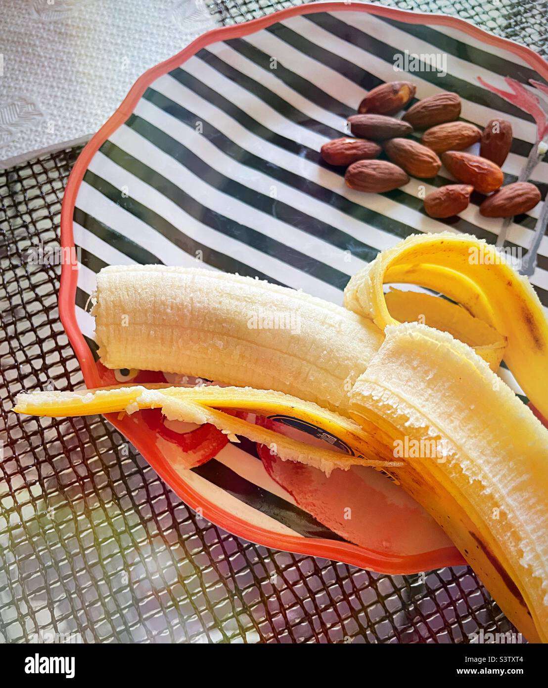 Close up of an afternoon snack of a fresh banana and almonds, 2022, USA Stock Photo