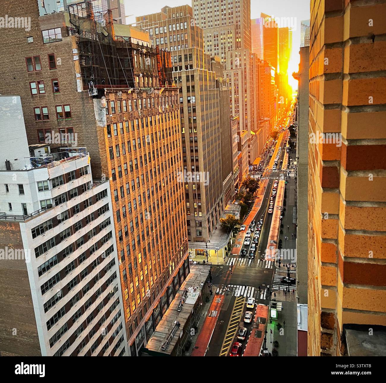 34th St. is aglow from the sunset during Manhattanhenge, summer 2022, New York City, USA Stock Photo