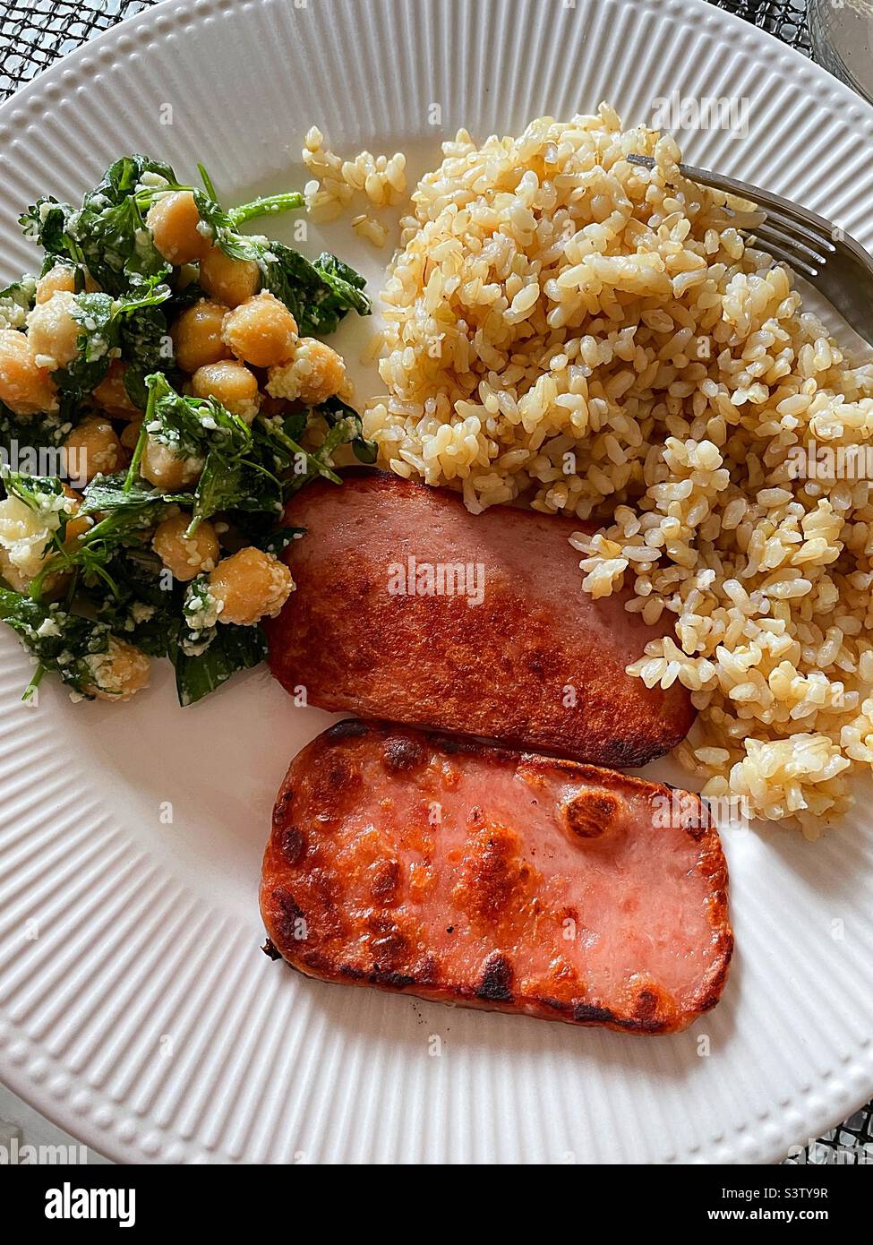 Close-up of a meal with fried Spam, brown rice and a garbanzo bean salad, 2022, United States Stock Photo