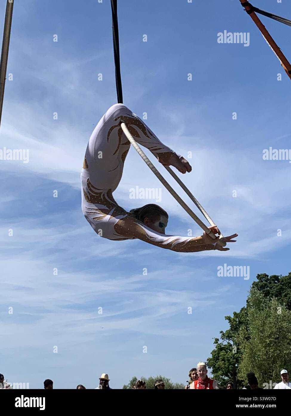 Female acrobat performing on suspended hula hoop Stock Photo