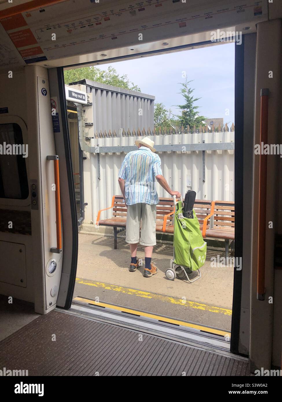 Man in summer outfit gets off from London overground train Stock Photo