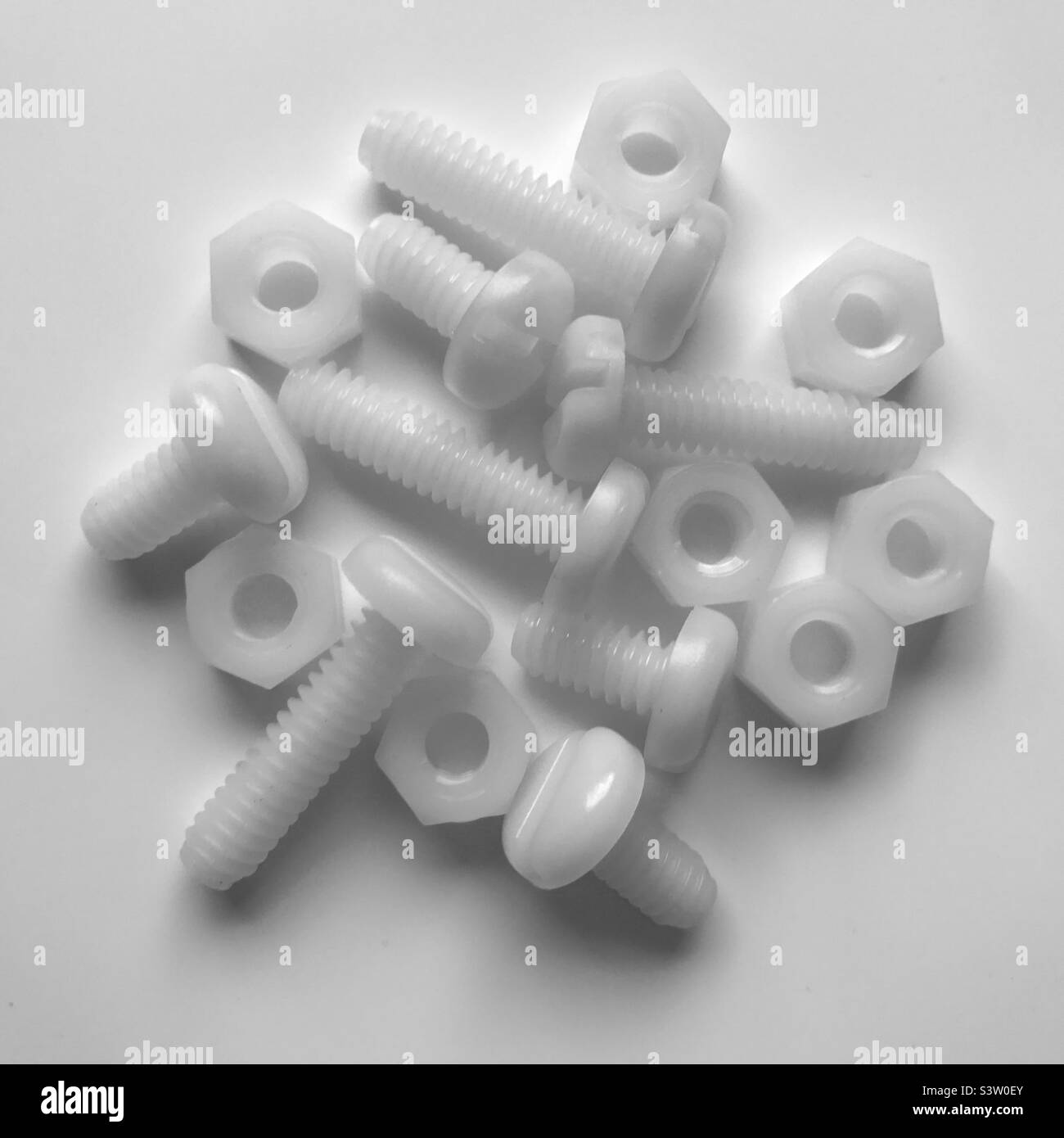 White nylon screws and nuts on white background. iPhone 13 Pro Stock Photo