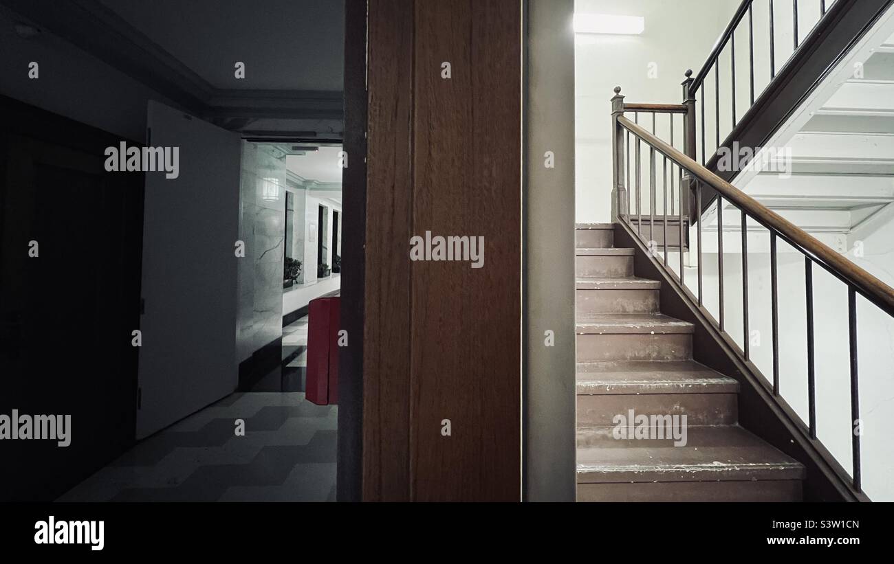 Split view of internal, fire escape staircase and a corridor receding into the distance in 1920s office building in Los Angeles, CA - Smartphone Captured Stock Image