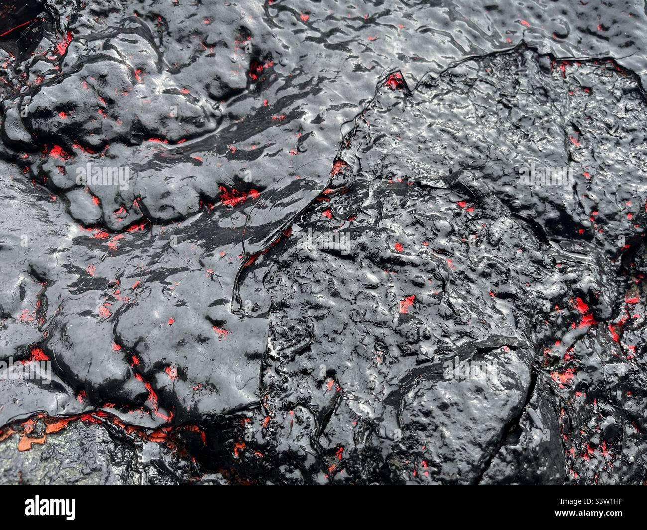 Black and red shiny paint on rock Stock Photo