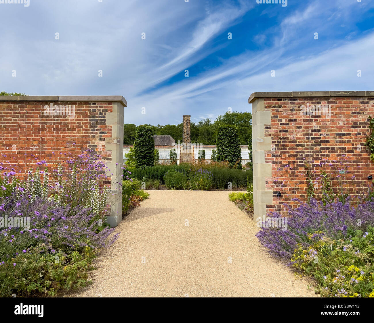 Looking through an opening in the wall into the paradise garden of RHS Bridgewater in Salford. UK - Smartphone Captured Stock Image