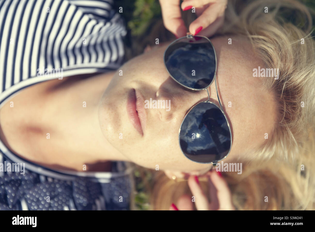 Pretty young blonde woman in sunglasses in summer, portrait - Smartphone Captured Stock Image