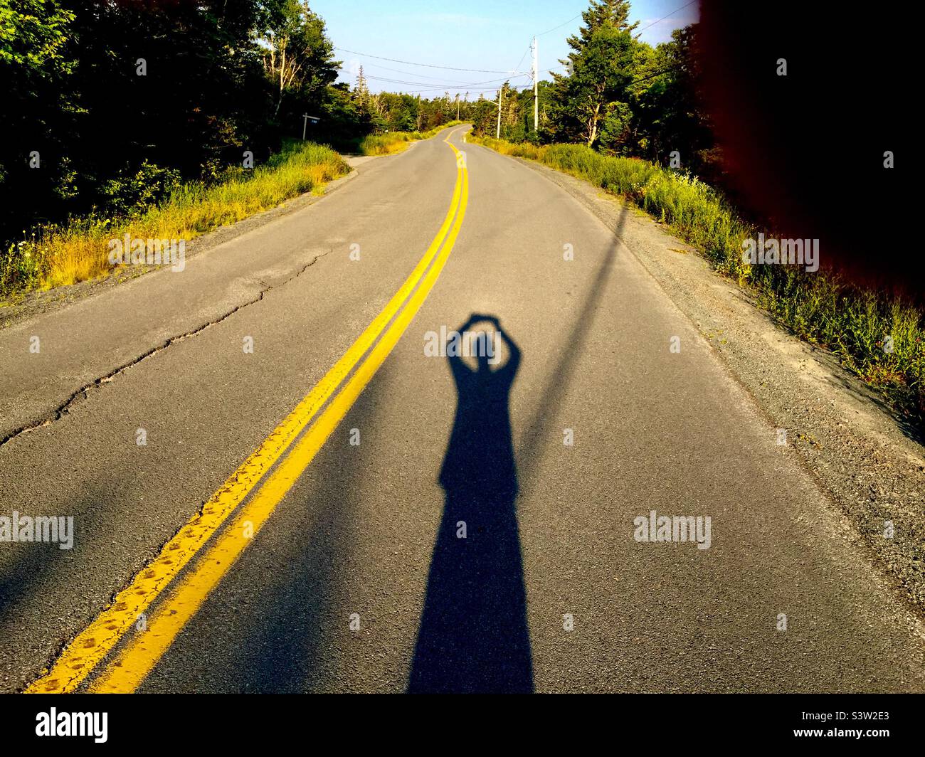 Photographing the long, winding road, Halifax, Canada. Camera over my head. Facing the challenge. Eye on the road. - Smartphone Captured Stock Image
