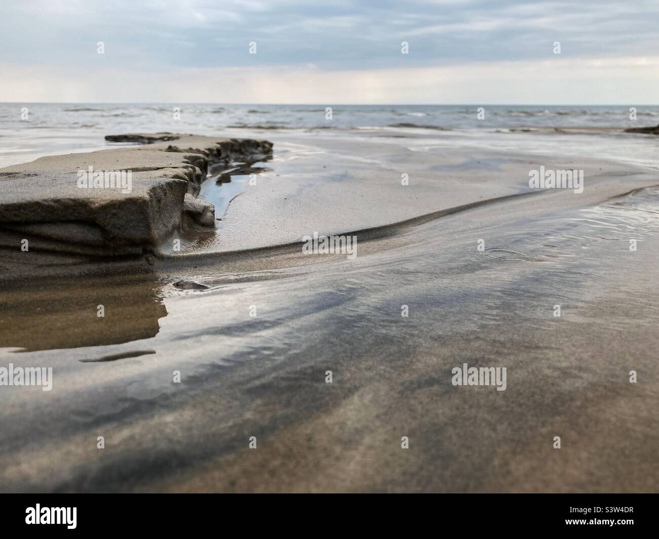 A Small „Cliff“ of Sand created by a River flowing Into the baltic sea in Sweden Stock Photo