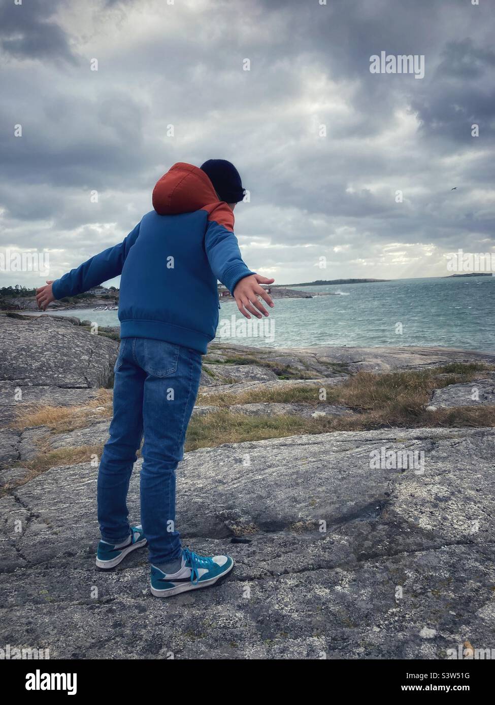 A pre-teen boy leaning into a strong Wind on the Swedish Coast - Smartphone Captured Stock Image