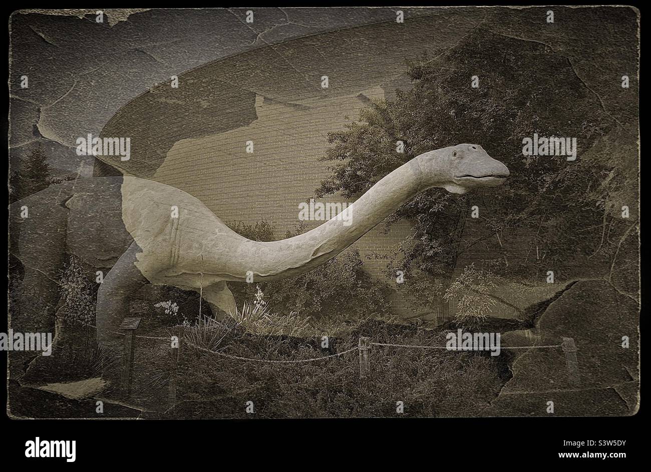 The outside grounds at the Dinosaur Museum in Vernal, Utah, USA. Visitors exploring these grounds will experience a prehistoric adventure. Color and grunge effects are digitally added. Stock Photo