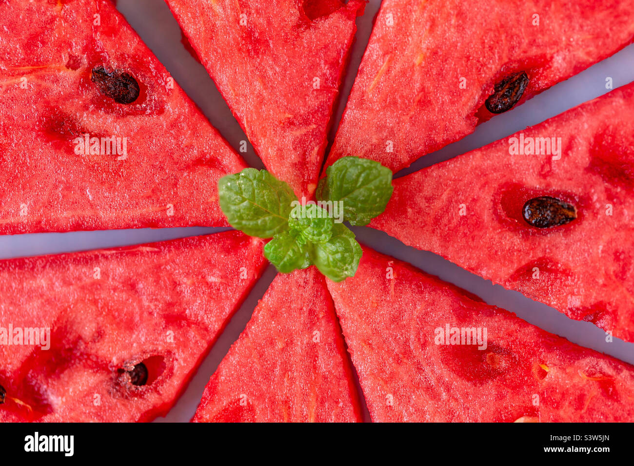 Fresh juicy sweet watermelon and mint leaves on it, closeup Stock Photo