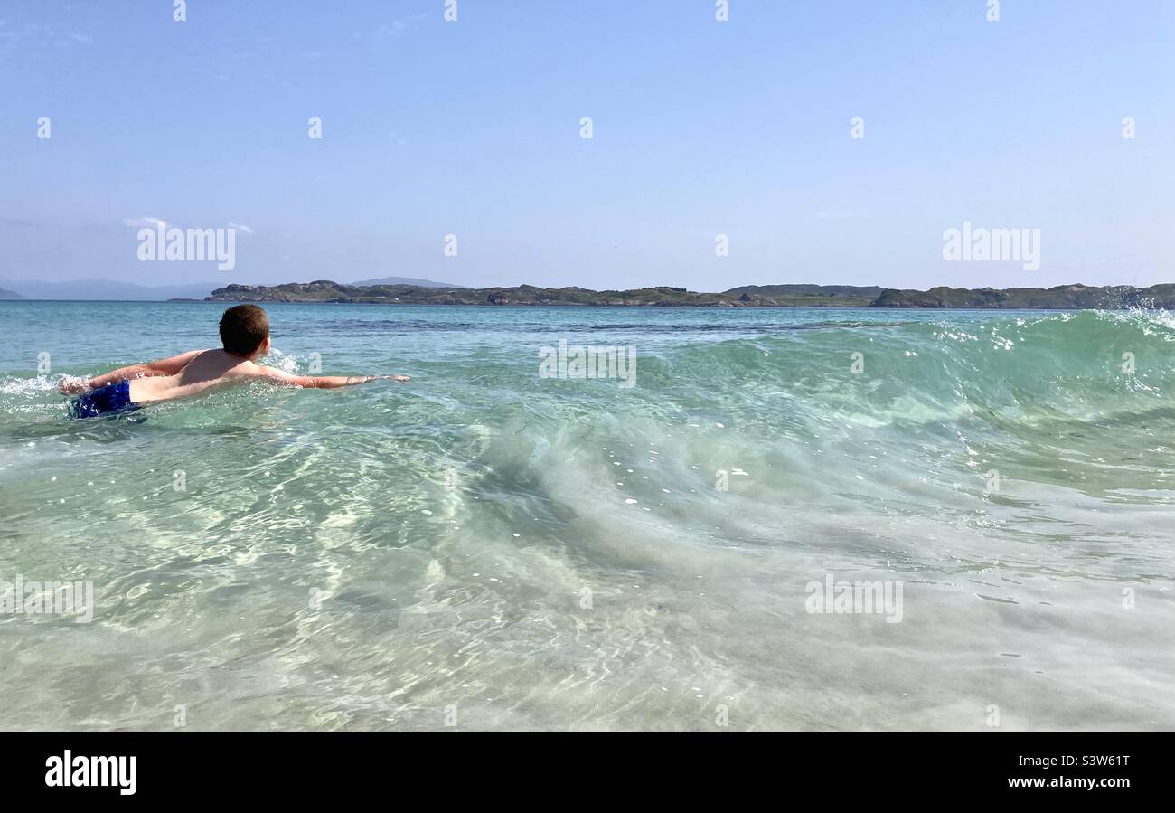 Young boy swimming in Iona, Scotland Stock Photo