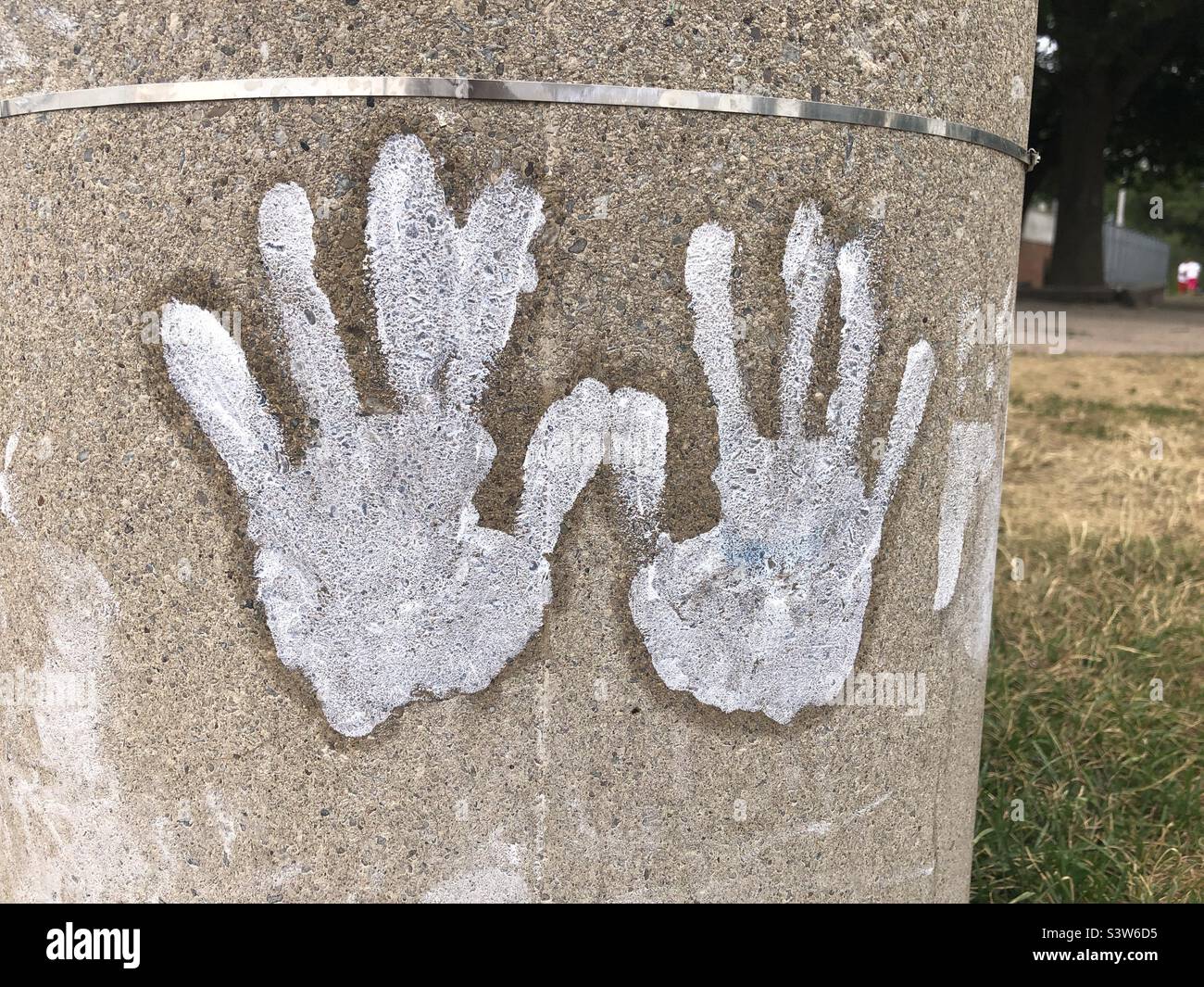 Painted white hands on a post. Stock Photo