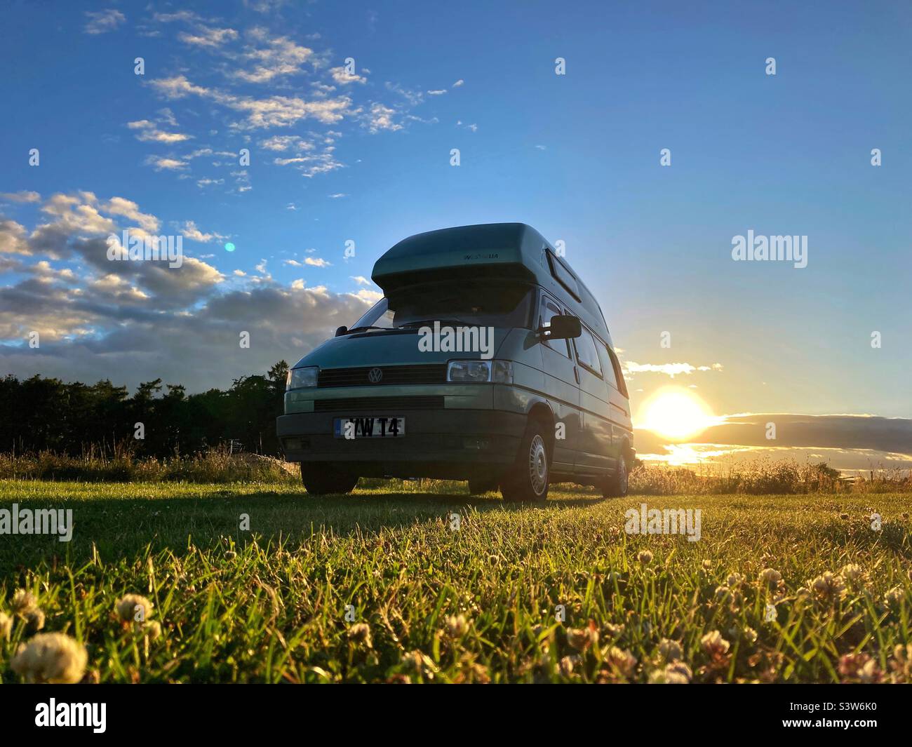 VW camper van on a campsite at sunset in Northumberland Stock Photo