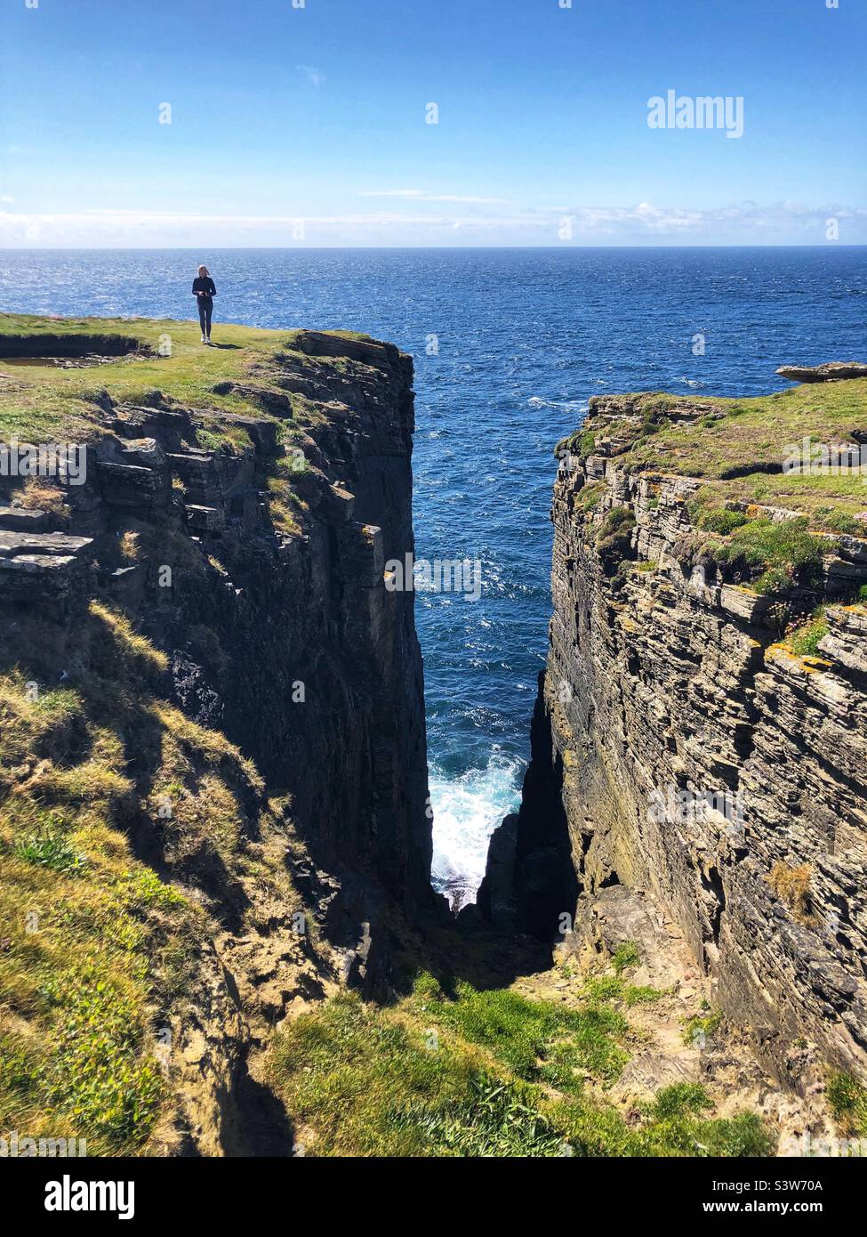 Walkers On The Coastal Path And Cliffs At The Brough Of Birsay Isle Of walkers-on-the-coastal-path-and-cliffs-at-the-brough-of-birsay-isle-of