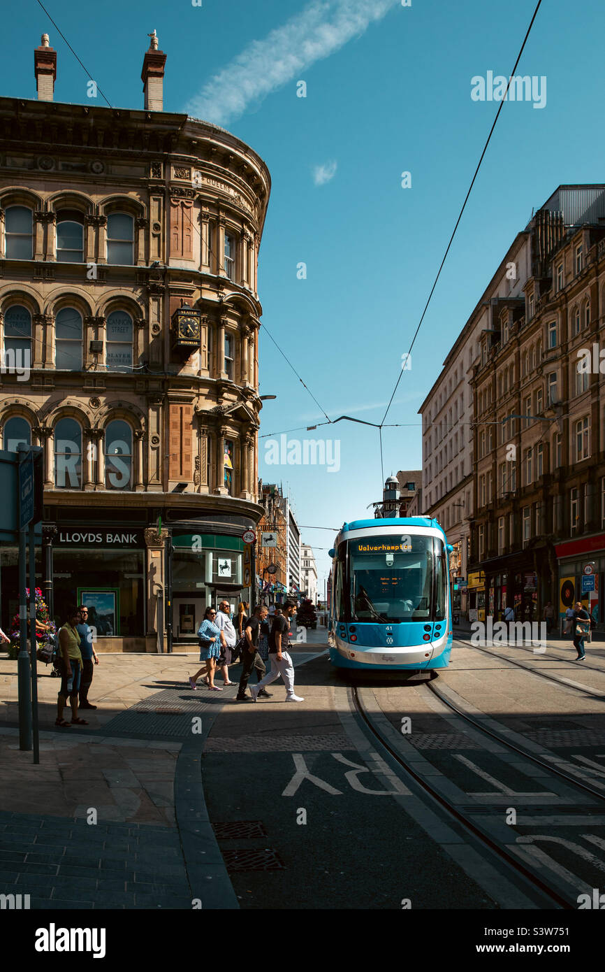 A West Midlands Metro Tram passing old buildings and architecture in the city centre of Birmingham Stock Photo