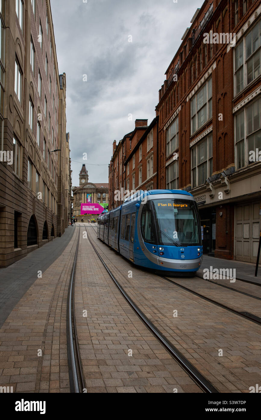 A West Midlands Metro tram on tracks through the streets of Birmingham on its way to Victoria Square during the Commonwealth Games 2022 - Smartphone Captured Stock Image