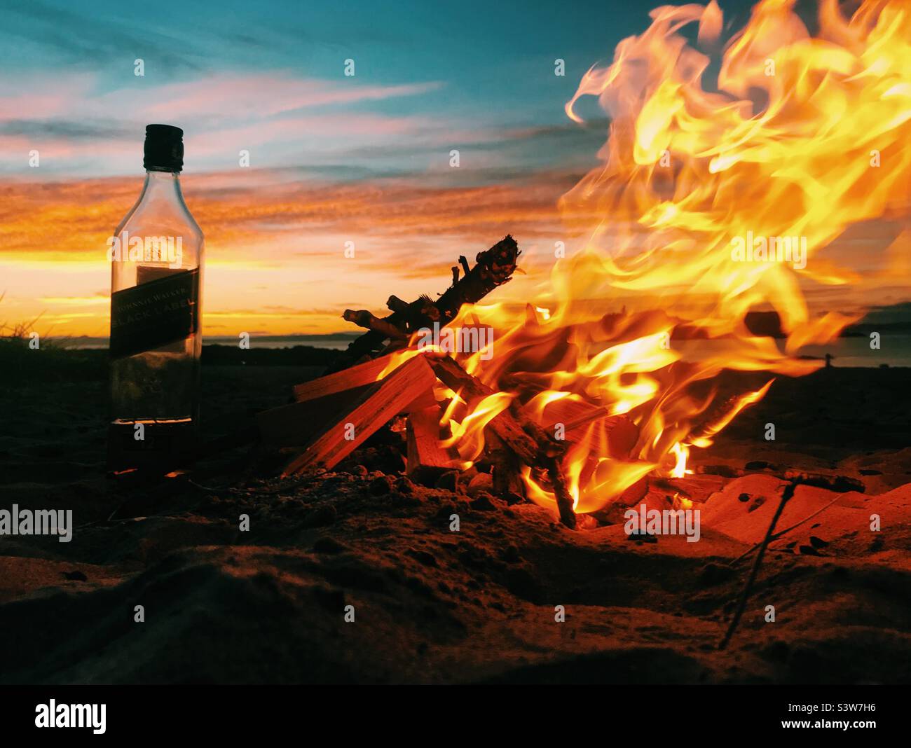 Sunset, fire and whisky on the beach in Scotland - Smartphone Captured Stock Image