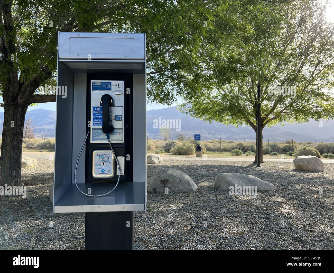 INDEPENDENCE, CA, APR 2022: payphone at a rest stop in the middle of wilderness, with mountains in background - Smartphone Captured Stock Image