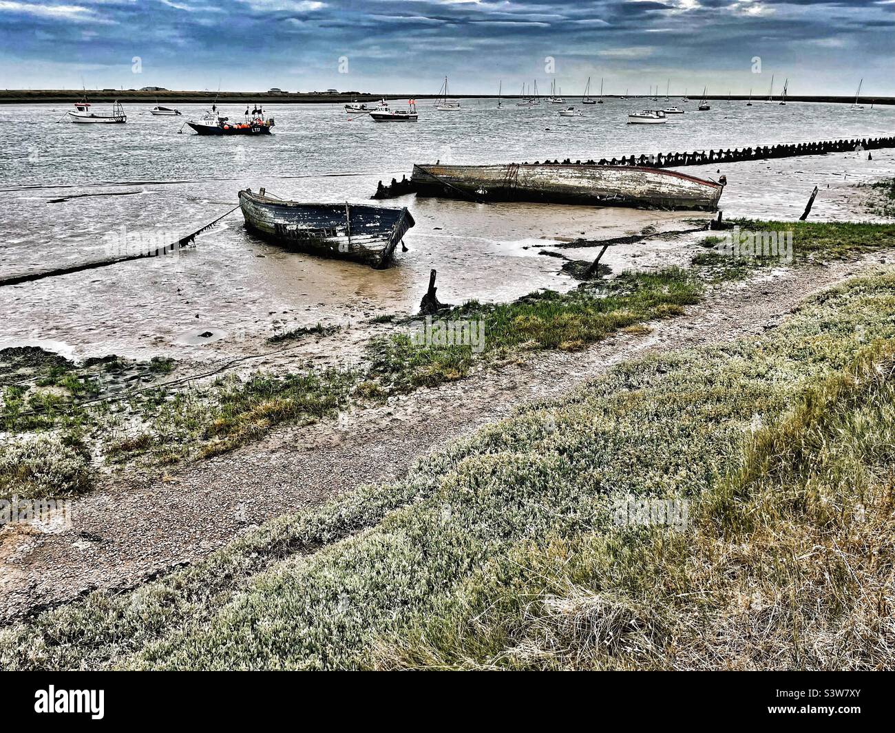 Loved and pre-loved. Used boats and abandoned boats on the River Ore at Orford, Suffolk, East Anglia, UK. Stock Photo