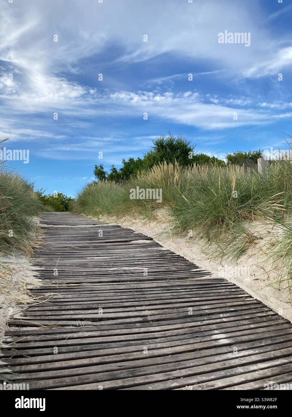 A Wooden walkway leading away from the Beach in Klintholm Havn, Denmark Stock Photo