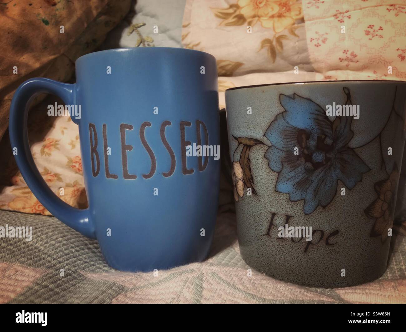 Two blue coffee mugs spelling out “Blessed” and “Hope” Stock Photo